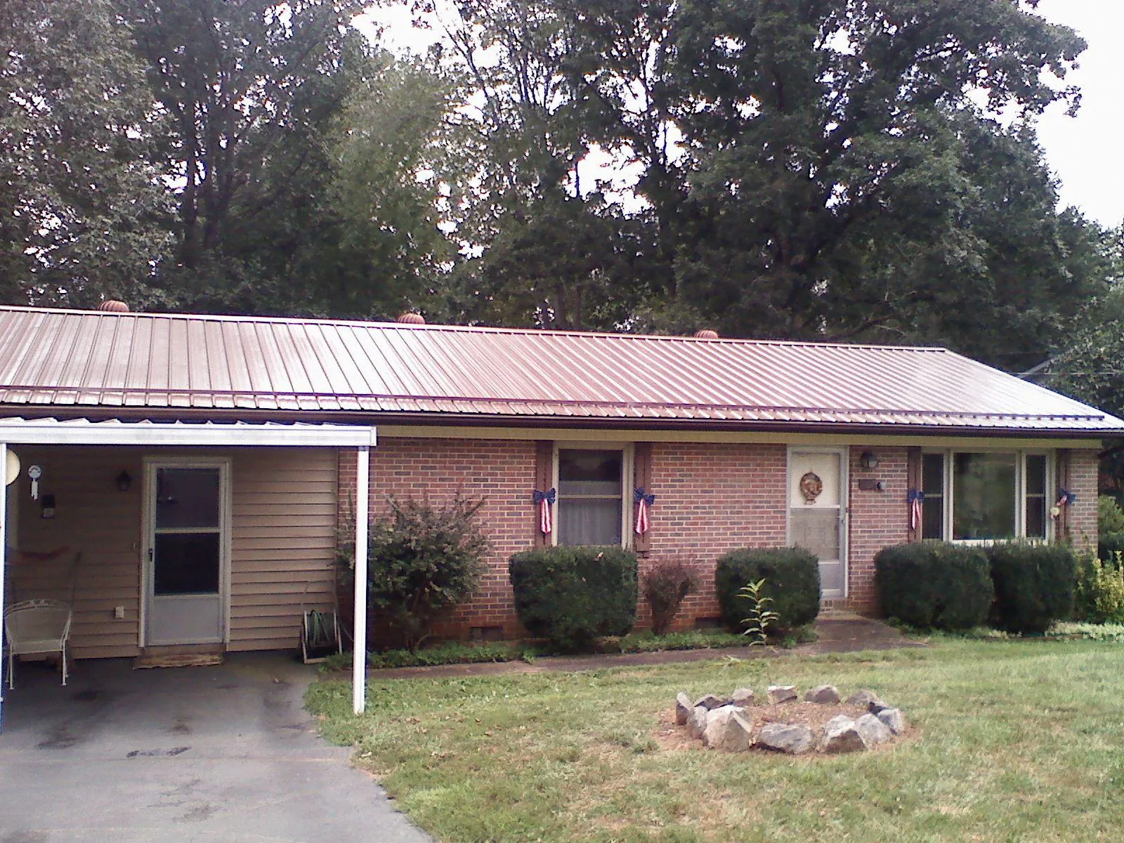 Bronze metal roof and carport on a brick ranch home — Roof Repair work by our crew in Waterford
